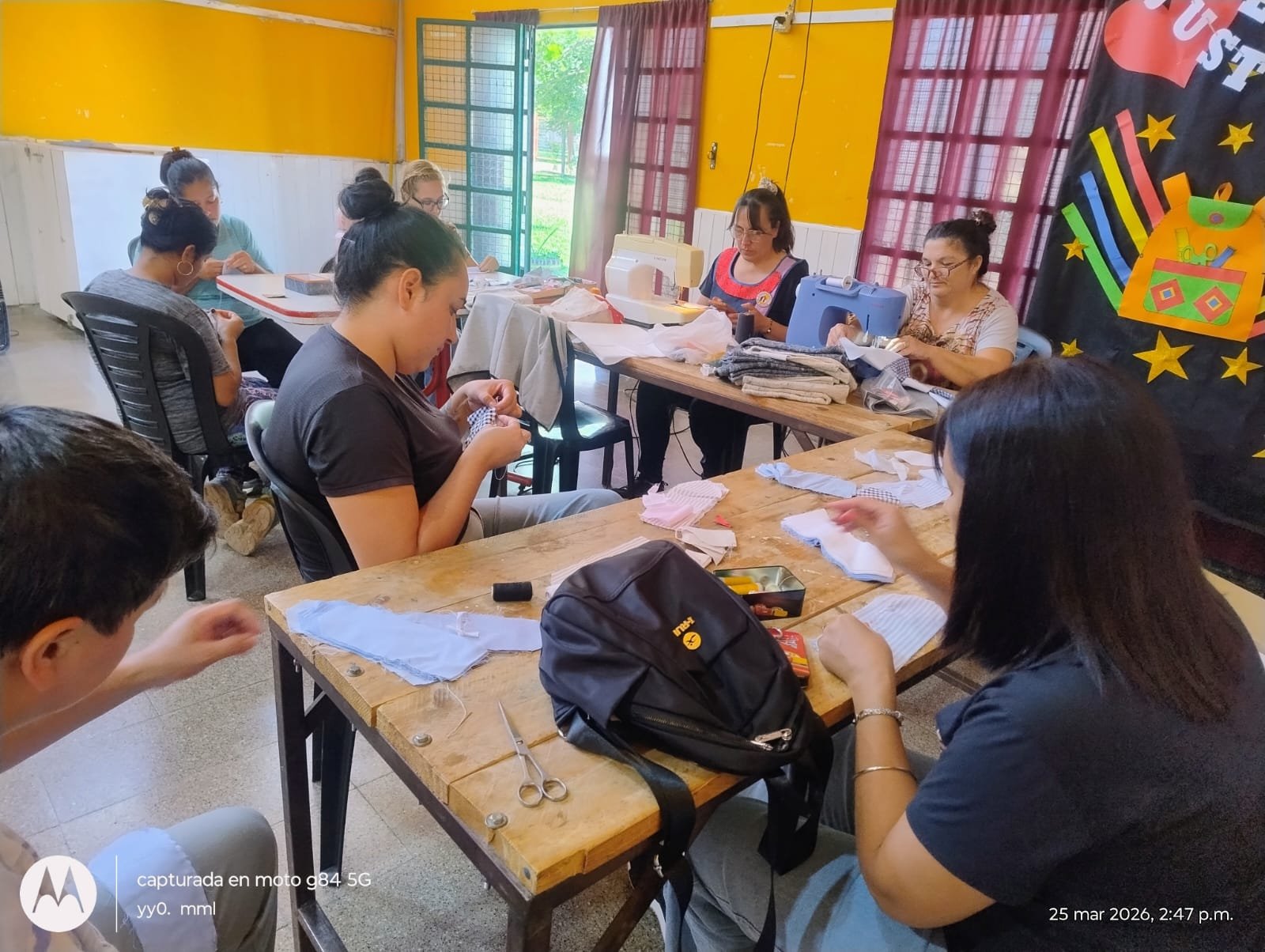 Estudiantes y docentes trabajando en el taller de costura